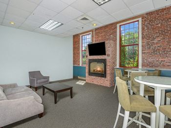 A living room with a fireplace and a table and chairs